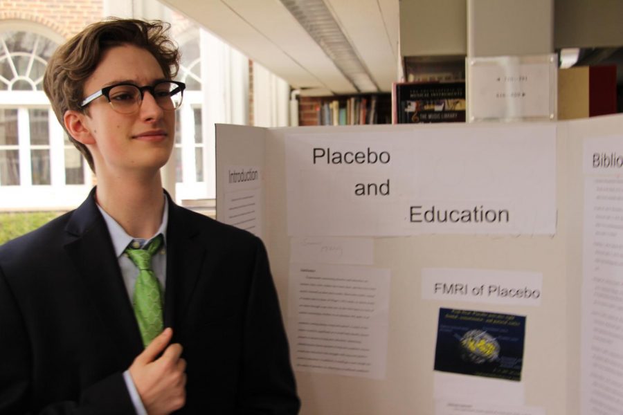 Sophomore Seamus McNulty presents his board at the Science Research Symposium. 
