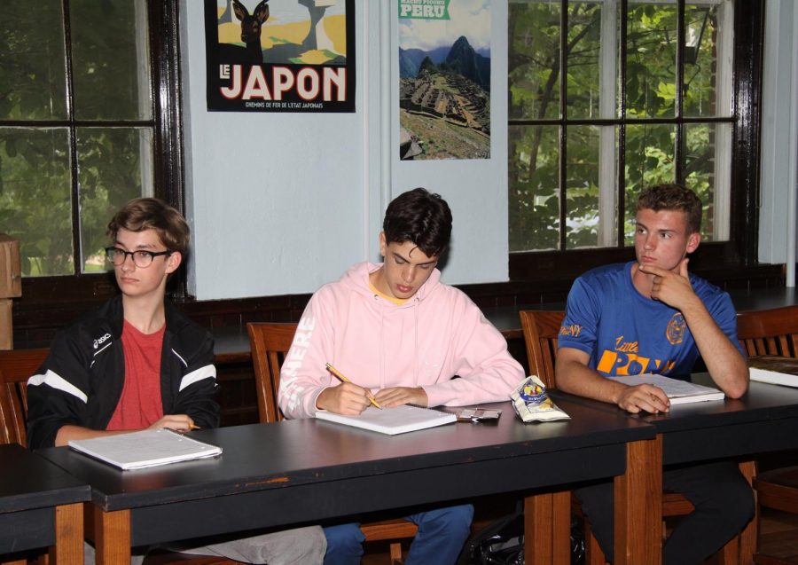 Juniors Seamus McNulty, Alexis Peetz Alio, and Leo Jordan take notes during class. 