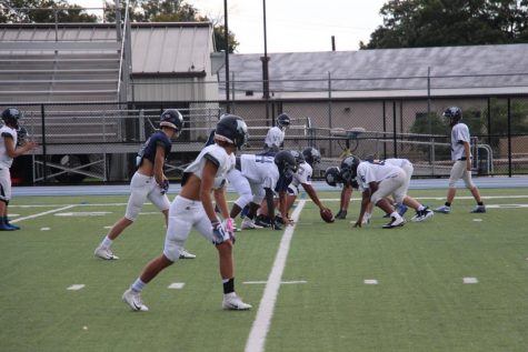 The Football team prepares to scrimmage during a practice at Poly.