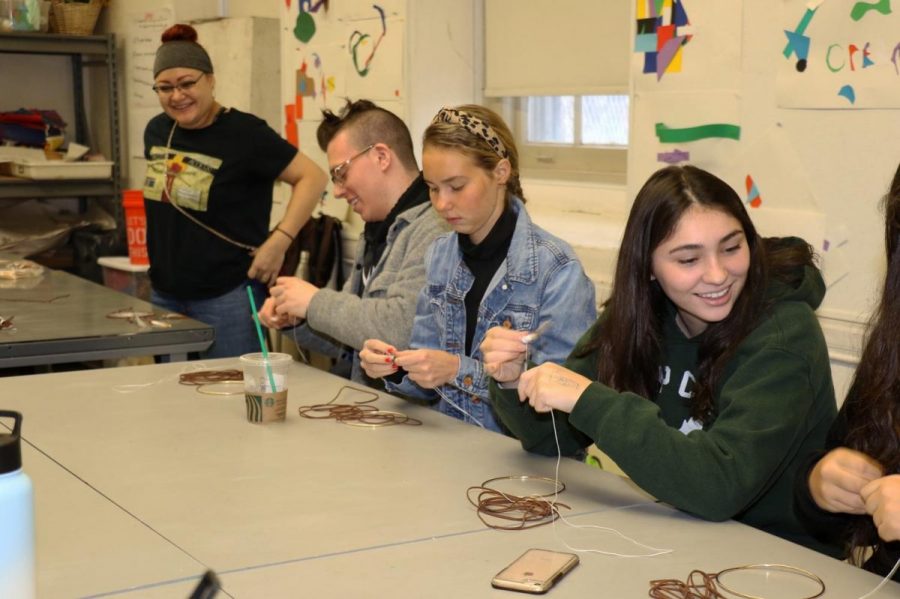 Multiple students creating dreamcatchers